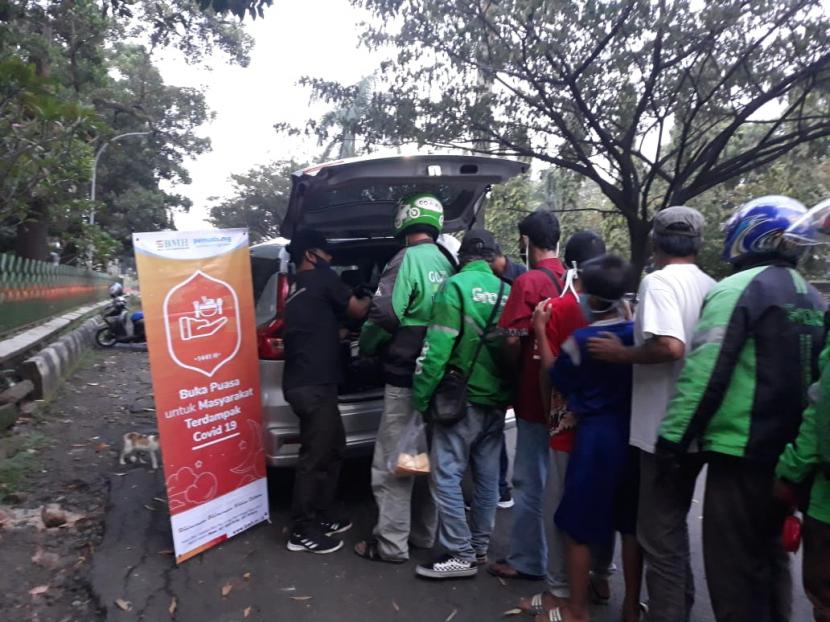 Warga mengantre paket Buka Puasa Berkah yang dbagikan  oleh BMH bekerja sama dengan Pemuda Hidayatulah.