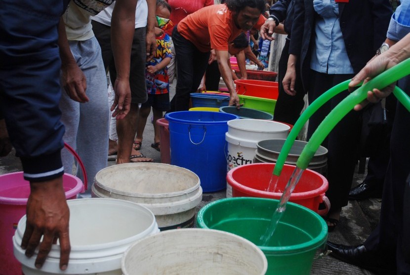 Warga mengantre saat pemberian bantuan air bersih oleh PDAM Tirtawening Kota Bandung di kawasan Muararajeun Kaler, di Bandung, Jawa Barat, Senin (4/9). 