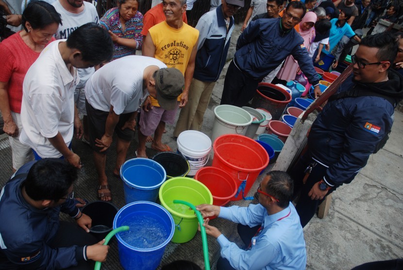 Warga mengantre saat pemberian bantuan air bersih oleh PDAM Tirtawening Kota Bandung di kawasan Muararajeun Kaler, di Bandung, Jawa Barat, Senin (4/9). 