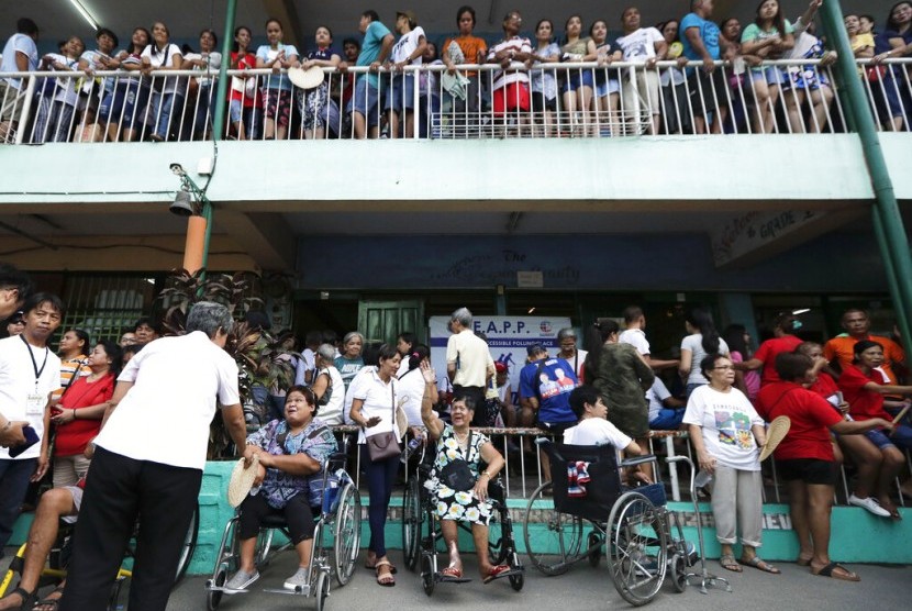 Warga mengantre untuk memberikan suara di tempat pemungutan suara di sekolah dasar Manuel L. Quezon di Manila, Filipina, Senin (13/5). Filipina menggelar pemilu paruh waktu hari ini.