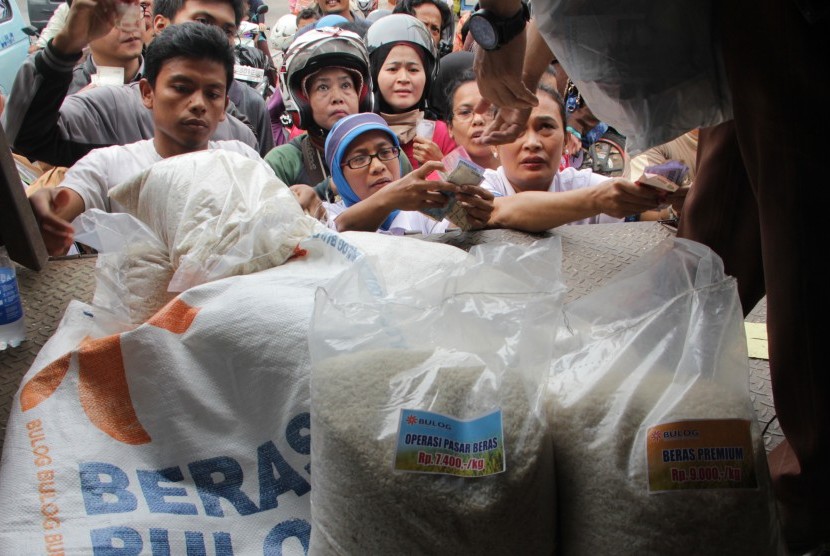 Warga mengantre untuk mendapatkan beras murah dari petugas Bulog Divre DKI Kelapa Gading, dalam operasi pasar beras di Pasar Jatinegara Jakarta Timur, Rabu (25/2). Pemerintah telah menyalurkan beras cadangan sebesar 25.000 ton beras untuk masyarakat miskin