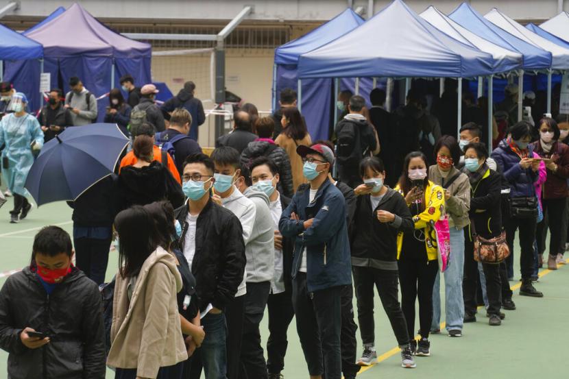 Warga mengantre untuk tes Covid-19 di Hong Kong. Infeksi Covid-19 di kota itu belum melewati puncaknya meskipun jumlah kasus harian mengalami sedikit penurunan. 