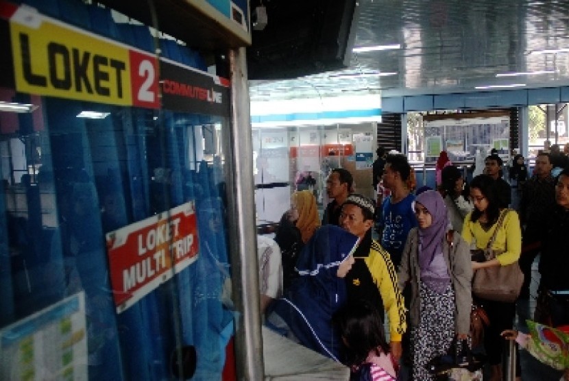 Warga mengantri tiket Kereta Rel Listrik (KRL) di Stasiun Juanda, Jakarta Pusat, Ahad (22/12).