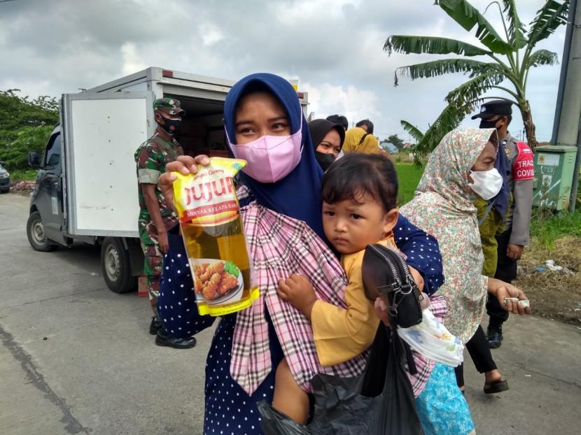 Warga mengantri untuk membeli minyak goreng dalam operasi pasar di Pasar Karangampel, Kecamatan Karangampel, Kabupaten Indramayu, Kamis (17/2/2022).