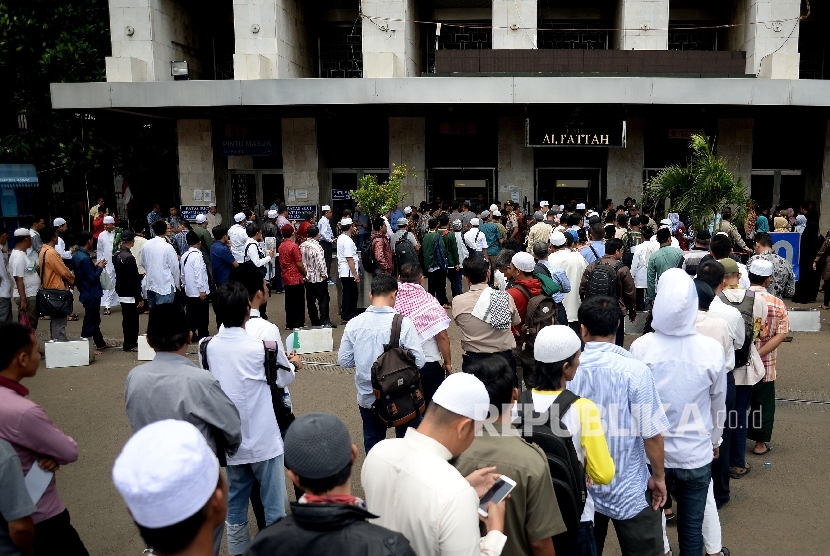 Warga mengantri untuk menjalani pemeriksaan sebelum masuk ke Masjid Istiqlal, Jakarta, Kamis (2/3).