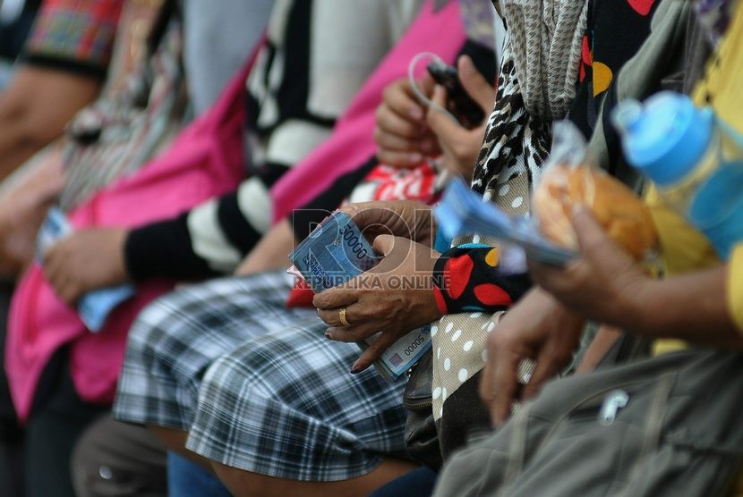  Warga mengantri untuk menukarkan uang pecahan di mobil layanan penukaran uang di Lapangan IRTI Monas, Jakarta Pusat, Jumat (11/7).   (Prayogi/Republika)