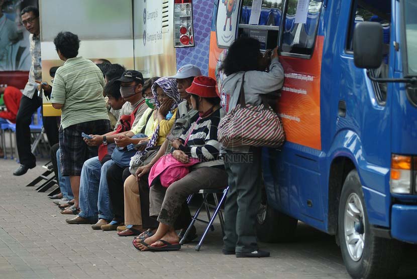 Warga mengantri untuk menukarkan uang pecahan di mobil layanan penukaran uang di Lapangan IRTI Monas, Jakarta, Jumat (11/7). (Republika/Prayogi) 