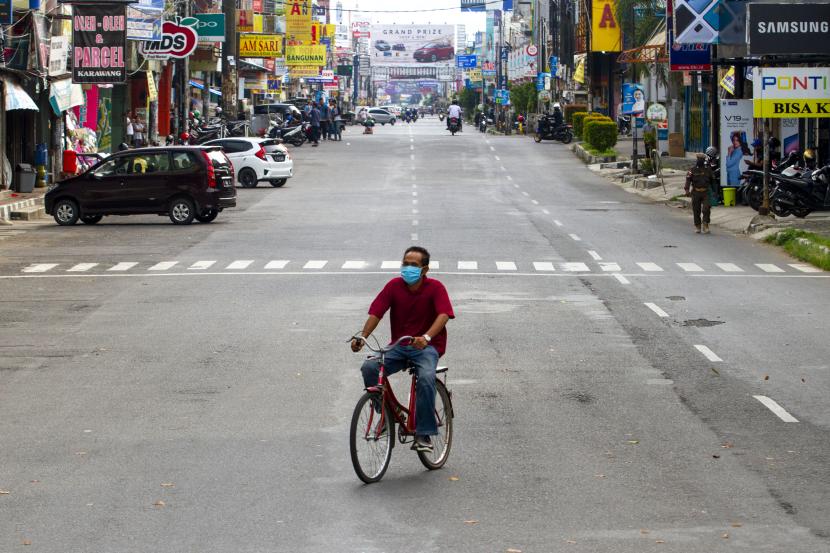 Warga mengayuh sepeda saat penerapan Pembatasan Sosial Berskala Besar (PSBB) di kawasan Tuparev, Karawang, Jawa Barat, Rabu (6/5). Pemerintah resmi memberlakukan penerapan PSBB di Kabupaten Karawang pada 6 Mei 2020 selama 14 hari.