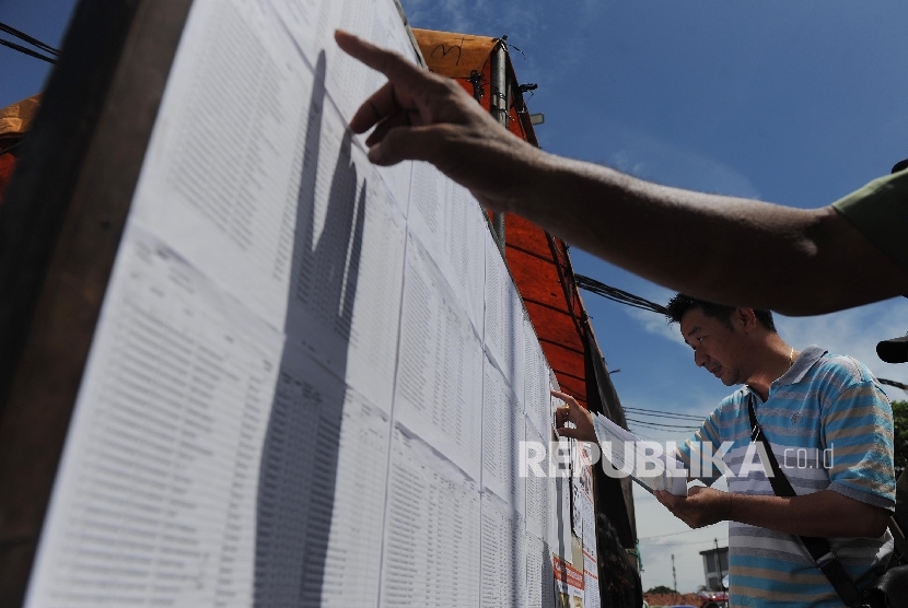  Warga mengecek Daftar Pemilih Tetap saat mengikuti Pilkada DKI Jakarta di TPS 17, Penjaringan, Jakarta Utara, Rabu (15/2).