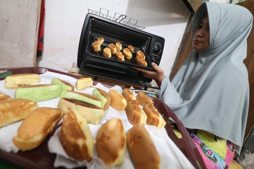 Warga mengeluakan roti isi keju dari oven untuk dijual melalui media sosial di Kota Kediri, Jawa Timur, Rabu (6/5/2020). PT PLN (persero) membebaskan tarif listrik selama enam bulan bagi pelanggan golongan bisnis usaha menengah, kecil dan mikro (UMKM) yang menggunakan listrik 450 VA guna menekan dampak pandemi COVID-19.