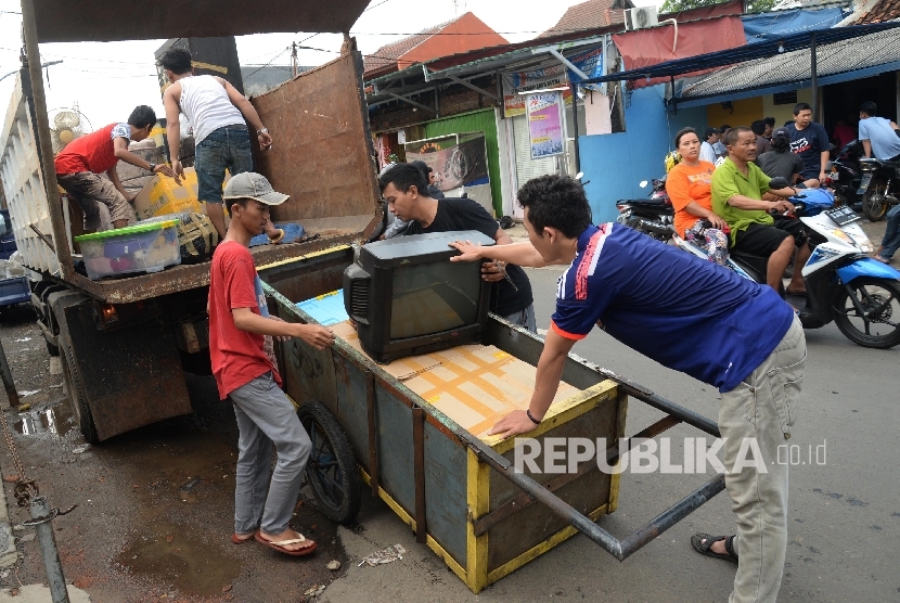 Warga mengemasi barang-barang di kawasan Bukit Duri, Jakarta Selatan, Ahad (14/8). (Republika/Yasin Habibi)