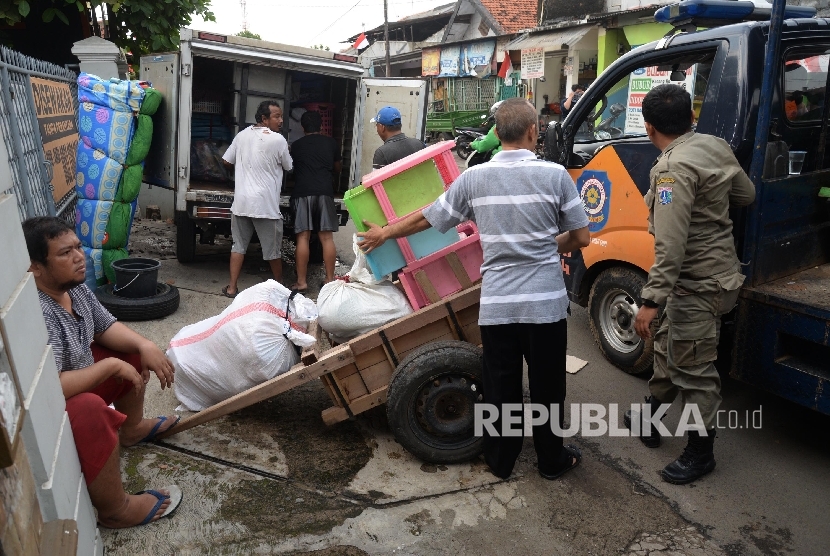 Warga mengemasi barang-barang di kawasan Bukit Duri, Jakarta Selatan, Ahad (14/8). (Republika/Yasin Habibi)