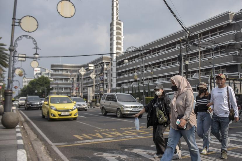 Warga mengenakan masker saat beraktivitas di kawasan Asia Afrika, Bandung, Jawa Barat, Ahad (17/12/2023).