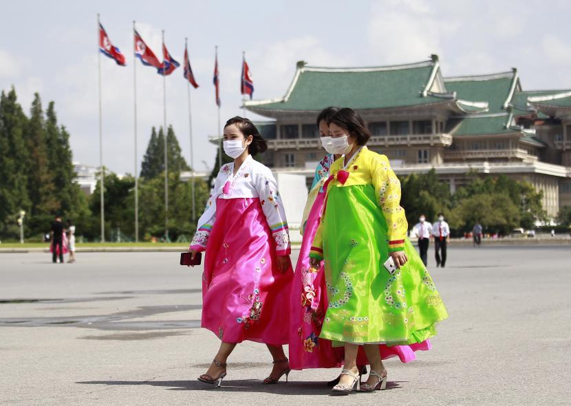 Warga mengenakan masker untuk membantu mengekang penyebaran virus corona berjalan di Pyongyang, Korea Utara, Rabu, 25 Agustus 2021.