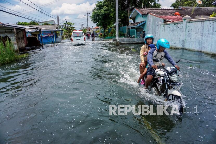 Warga mengendarai sepeda motor melewati jalan terdampak banjir di Pekalongan, Jawa Tengah (ilustrasi)