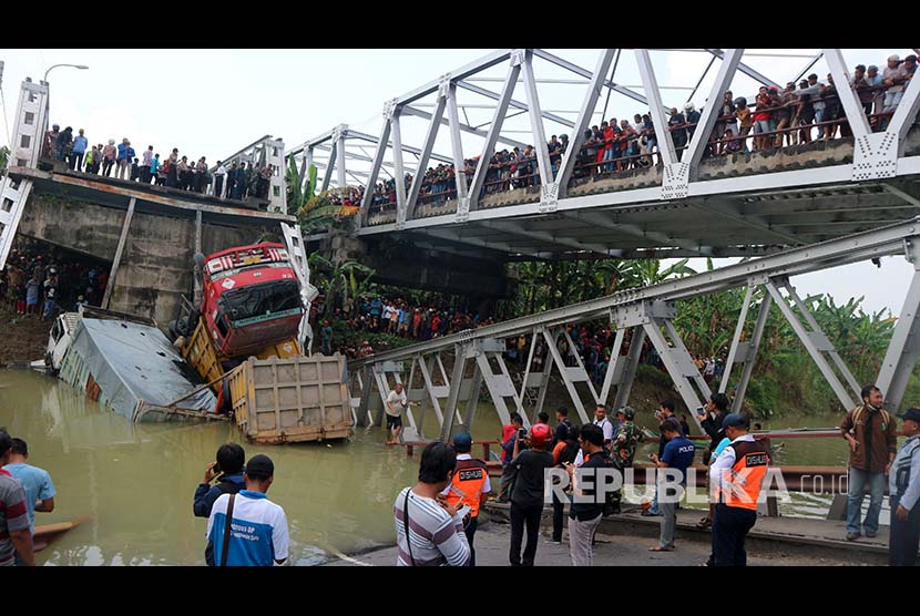 Warga mengerumuni lokasi jembatan Widang yang runtuh, Tuban, Jawa Timur, Selasa (17/4). Sisi barat jembatan itu runtuh sekitar 50 meter dan mengakibatkan satu pengemudi truk meninggal dunia, dan melukai tiga korban lainnya, sementara tiga truk dan sebuah sepeda motor masuk ke Bengawan Solo. 