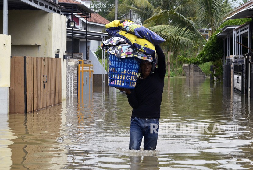 Warga mengevakuasi barang-barang dari rumanya yang terendam banjir di Way Kandis, Bandar Lampung, Lampung, Ahad (29/12/2019). 