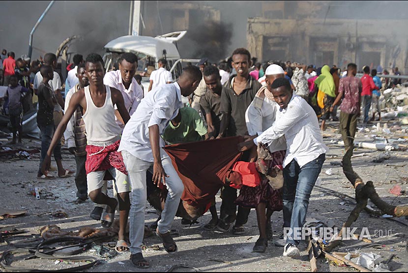 Warga mengevakuasi korban di lokasi ledakan bom di depan Safari Hotel, Mogadishu, Somalia, (14/10) waktu setempat