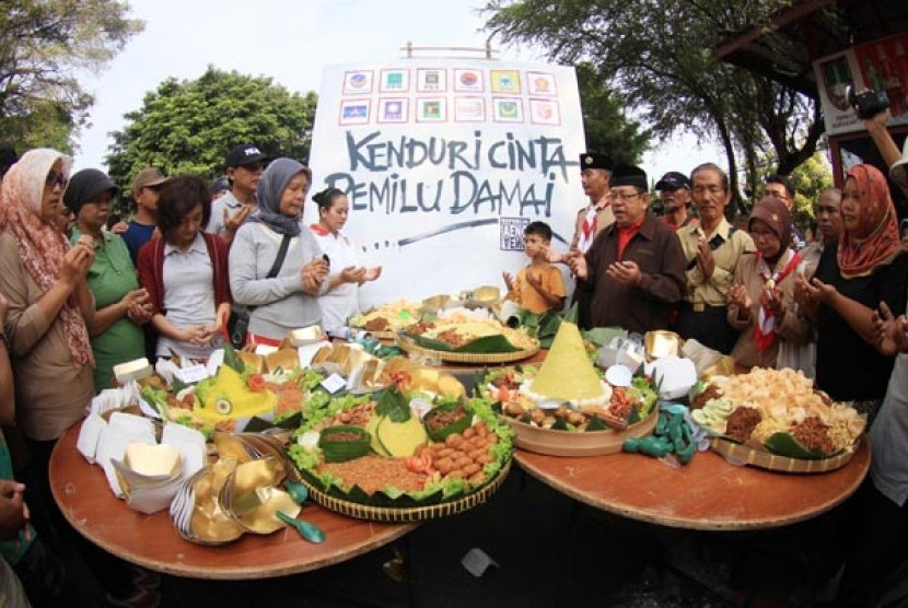 Warga menggelar tumpengan bersama guna menyambut datangnya Pemilu 2014 di Solo, Jateng, Minggu (6/4). Dalam kegiatan tersebut mereka juga melakukan doa bersama agar Pesta demokrasi mendatang berjalan dengan lancar dan aman.