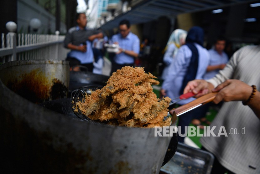 Warga menggoreng ikan dalam acara Makan Ikan Bersama di kantor Kementerian Kelautan dan Perikanan, Jakarta, Kamis (21/11/2019).