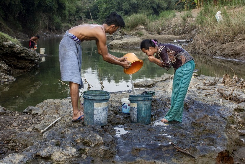 Warga menggunakan air dari sumur buatan di Sungai Cibeet, kampung Jatimulya, Desa Wanakerta, Telukjambe Barat, Karawang, Jawa Barat, Minggu (26/5/2019).