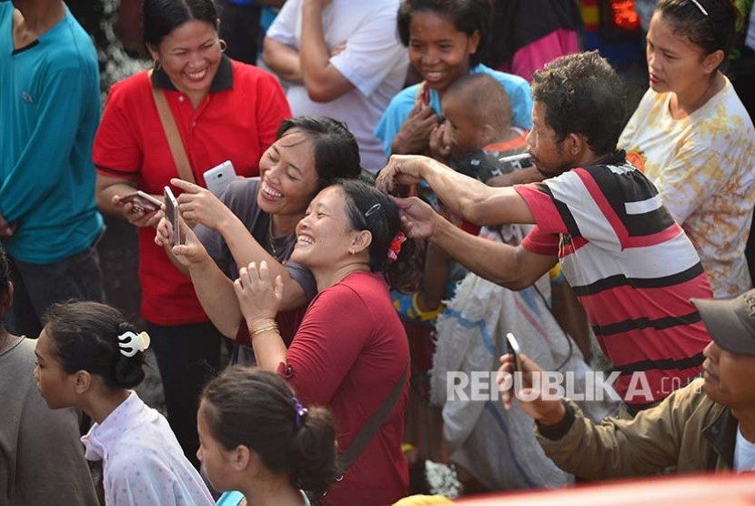 Warga menggunakan camera ponsel untuk memotret kebakaran yang melalap Gedung Ramayana Pasar Minggu, Kamis (18/5)