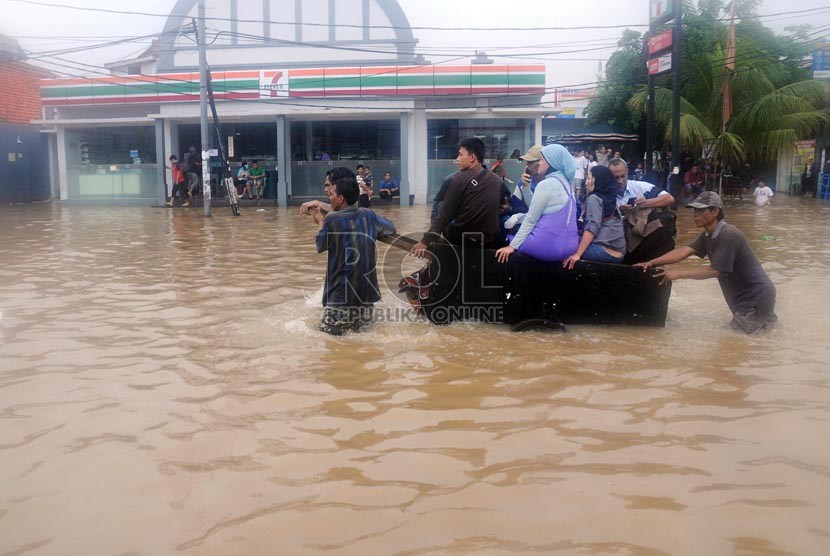   Warga menggunakan gerobak untuk evakuasi saat banjir melanda di Kebon Baru, Tebet, Jakarta Selatan, Rabu (16/1). (Republika/Aditya Pradana Putra)