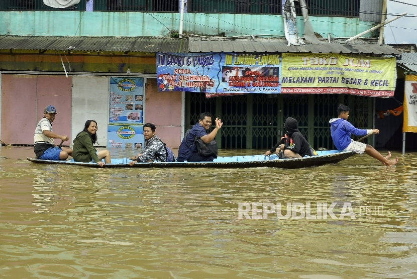  Warga menggunakan jasa perahu kayu untuk menerobos banjir yang merendam di Jalan Raya Banjaran di Kelurahan Andir, Kecamatan Baleendah, Kabupaten Bandung, Rabu (8/3).