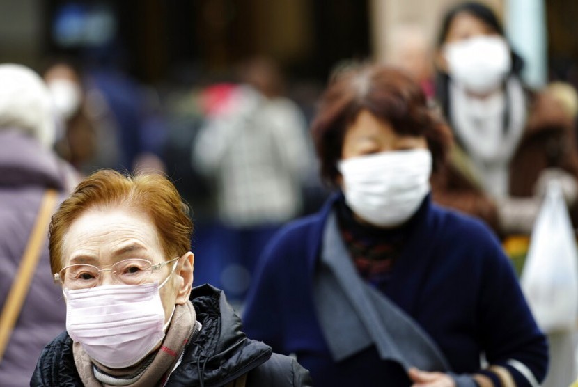 Warga menggunakan masker untuk menghindari penyebaran virus corona di Wuhan, China.