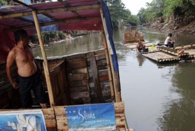 Warga menggunakan MCK darurat di bantaran kali Ciliwung, Bukit Duri, Jakarta, Senin (19/3). (Republika/Adhi Wicaksono)