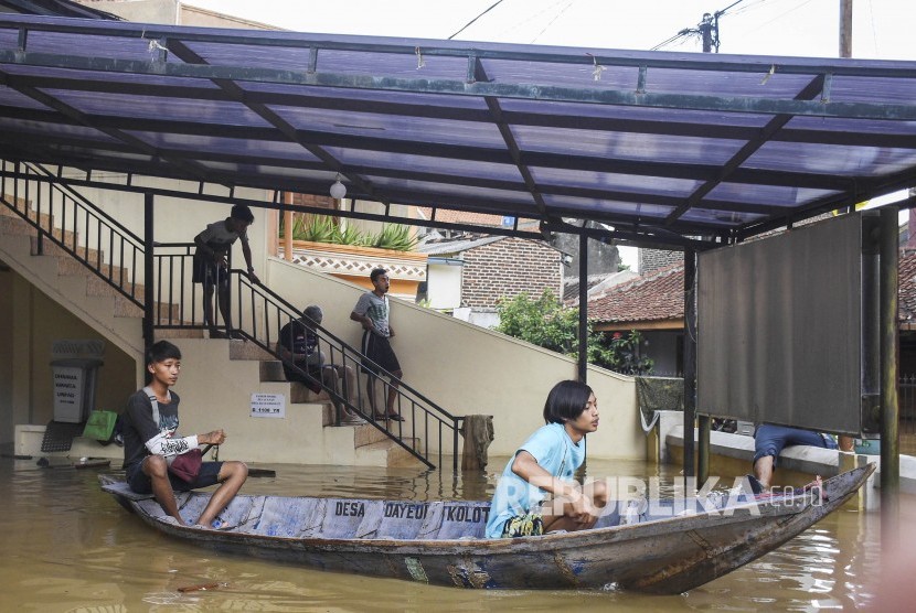 Warga menggunakan perahu di depan Gedung Pengungsian Aula Desa Dayeuhkolot, Kecamatan Dayeuhkolot, Kabupaten Bandung. Ilustrasi