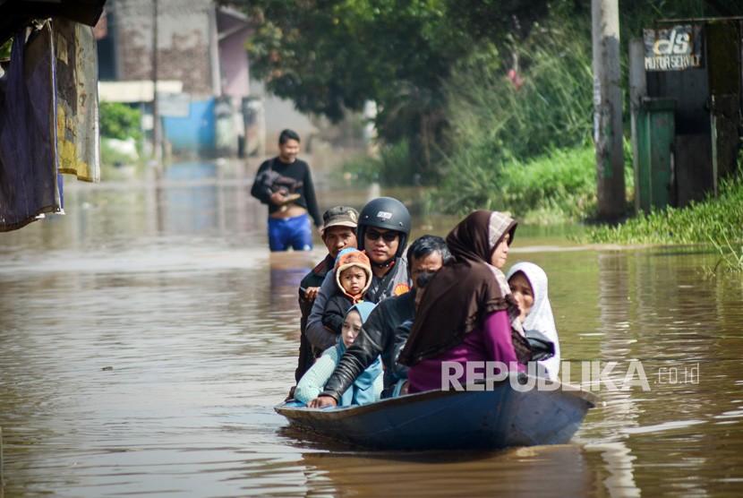 Warga menggunakan perahu kayu melintasi banjir di Dayeuhkolot, Kabupaten Bandung, Jawa Barat (ilustrasi)
