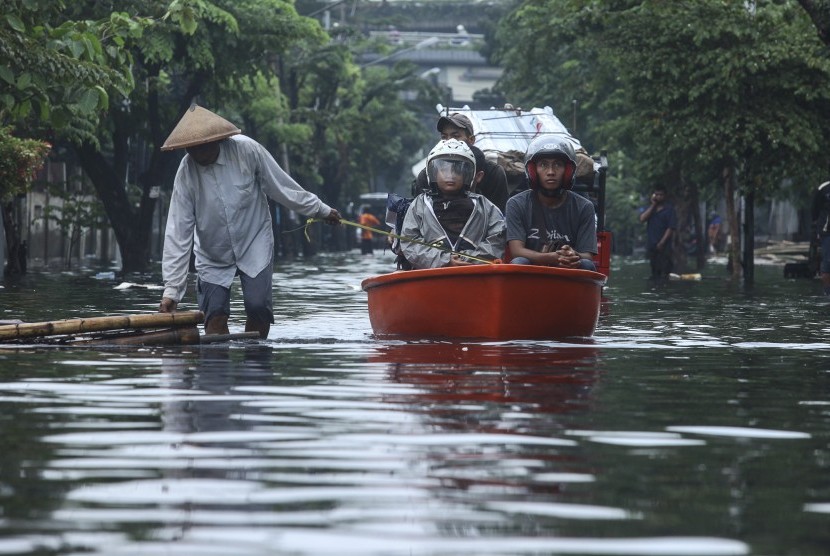 Warga menggunakan perahu melewati banjir di kawasan Rawa Buaya di Jakarta, Jumat (26/2). (Antara/Muhammad Adimaja)