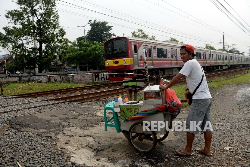  Warga menggunakan perlintasan kereta apa ilegal di Kawasan Buaran, Jakarta Timur, Kamis (23/3). 