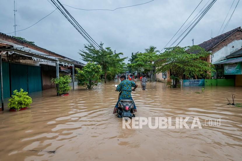 Warga menggunakan roda dua berusaha menerobos banjir di Rangkasbitung, Lebak, Banten