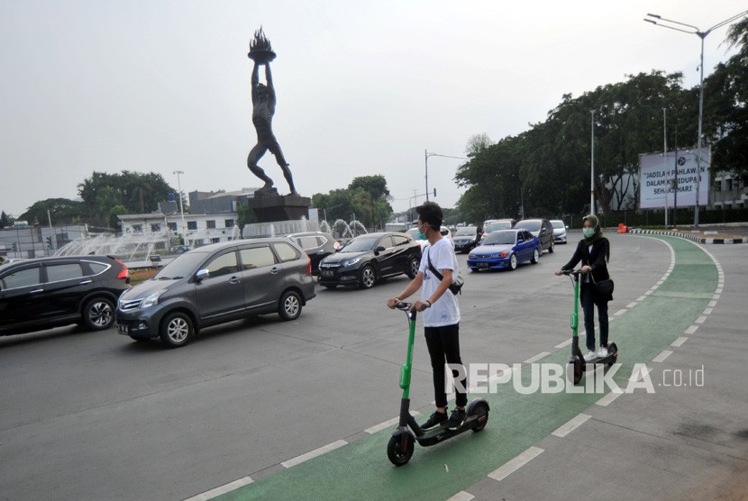 Warga menggunakan skuter listrik di kawasan Senayan, Jakarta, Sabtu (23/22/2019).