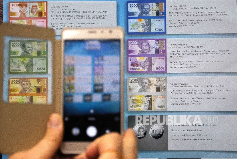 Resident took a photograph of the sample of new banknotes in the launching of new banknotes at Blok M Square, Jakarta, on Monday (December 19, 2016).