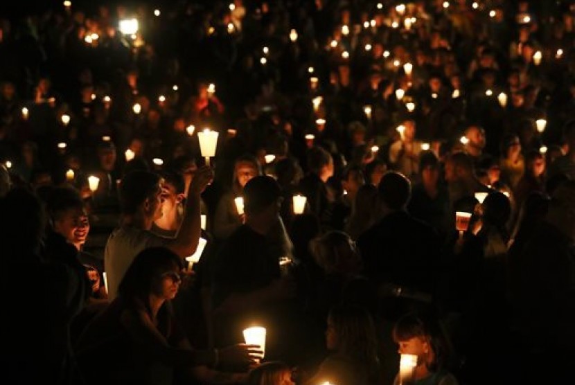 Warga menghadiri acara menyalakan lilin memperingati korban tewas di Umpqua Community College, Oregon, Kamis (1/10).