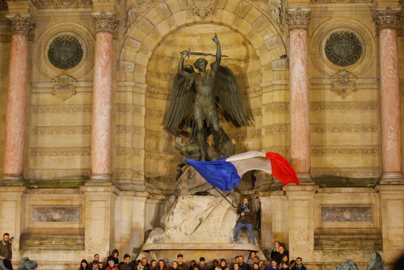 Warga menghadiri peringatan kebakaran Katedral Notre-Dame di Paris, Prancis, Selasa (16/4). Petugas berhasil memadamkanapi setelah berjuang selama 12 jam. 