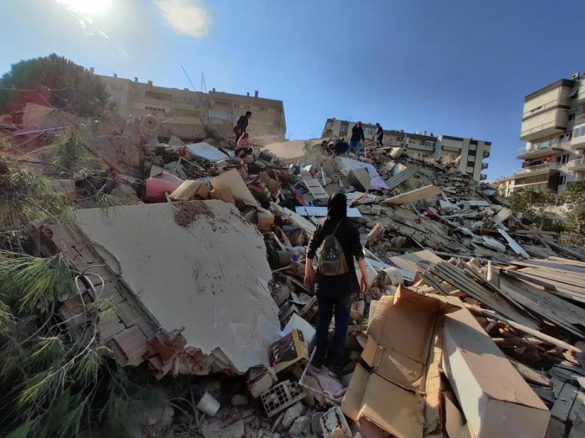 Warga menghampiri gedung yang runtuh setelah gempa berkekuatan 7.0 yang berpusat di Laut Aegea mengguncang Izmir, Turki, 30 Oktober 2020.