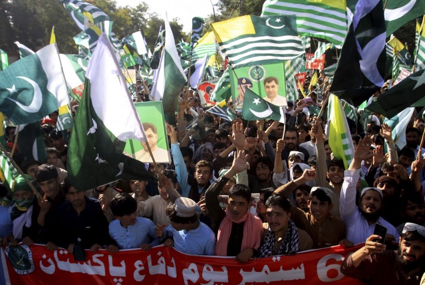  Warga mengibarkan bendera Kashmir dalam unjuk rasa memperingati Hari Pertahanan Pakistan di Quetta, Pakistan, Jumat (6/9).