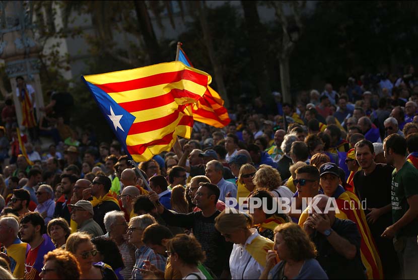 Warga mengibarkan bendera Katalan pada unjuk rasa di Barcelona