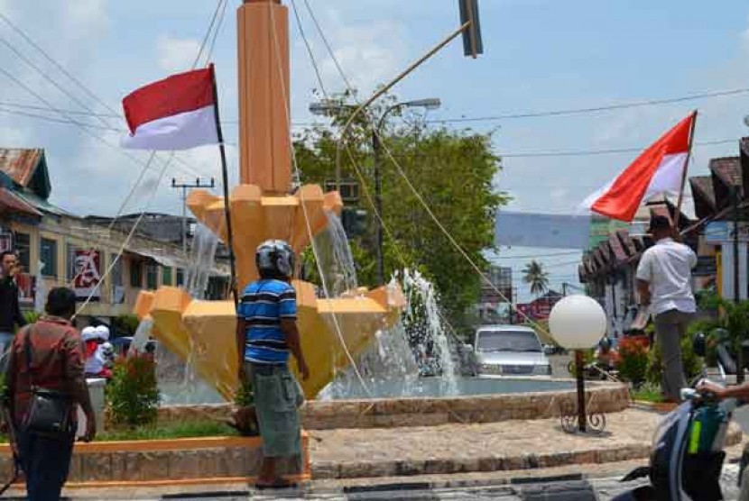 Warga mengibarkan bendera merah putih di pusat kota Meulaboh Kab. Aceh Barat, Aceh, Ahad (31/3).
