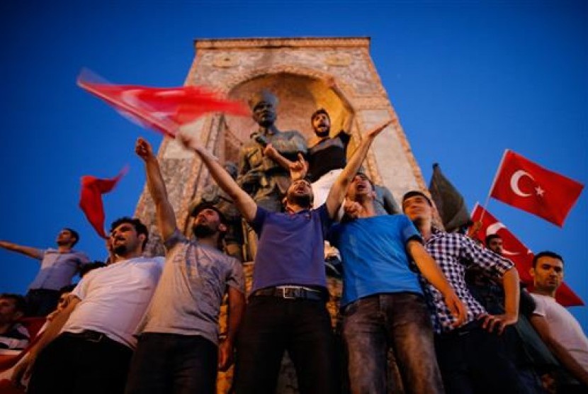 Warga mengibarkan bendera Turki saat berkumpul di Lapangan Taksim, Sabtu, 16 Juli 2016. Warga turun ke jalan menolak aksi kudeta terhadap Presiden Turki Recep Tayyip Erdogan.