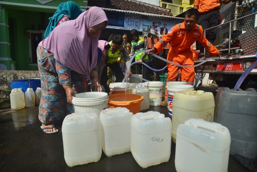 Warga mengikuti pembagian air bersih yang didistribusikan oleh Satlantas Polres Kota bekerja sama dengan BPBD Kota Tasikmalaya, Kampung Singkup, Jawa Barat, Selasa (19/9). 