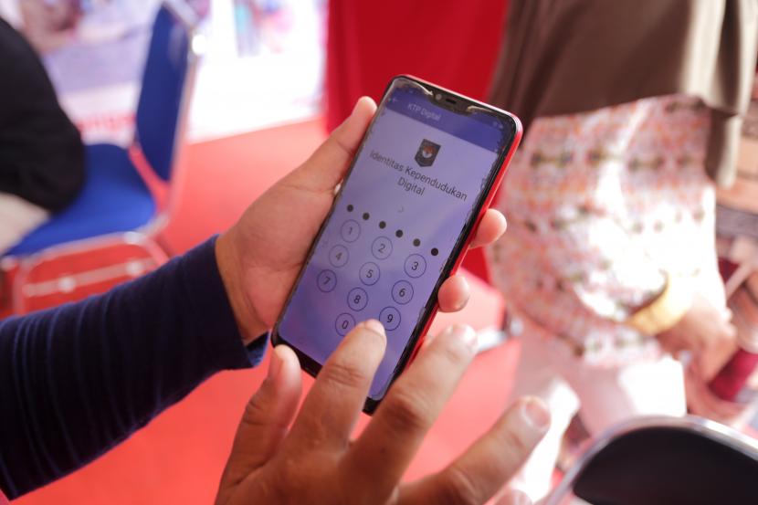Warga mengoperasikan aplikasi KTP Digital ponsel miliknya di Indramayu, Jawa Barat, Senin (10/10/2022). Dinas Kependudukan dan Catatan Sipil setempat memberikan layanan pembuatan Kartu Tanda Penduduk (KTP) Digital di sejumlah area publik untuk mempermudah dan mempercepat masyarakat dalam memperoleh dokumen kependudukan dan pencatatan sipil. 