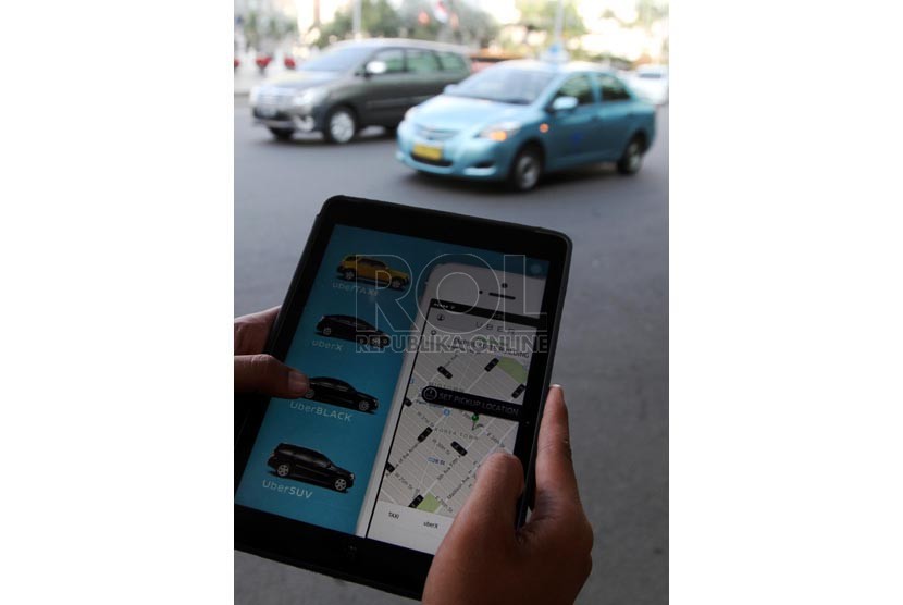  Warga mengoperasikan aplikasi taksi daring via gadget. (ilustrasi)