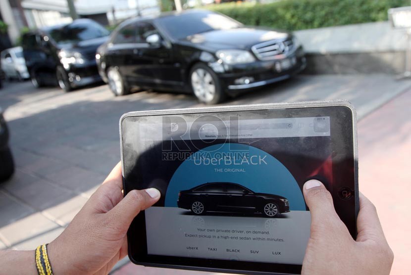 Warga mengoperasikan aplikasi taksi uber via internet di Jakarta. (Republika/ Yasin Habibi)