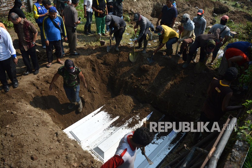 Warga mengubur jenazah terduga teroris di pemakaman Pucang, Sidoarjo, Jawa Timur, Ahad (20/5). 
