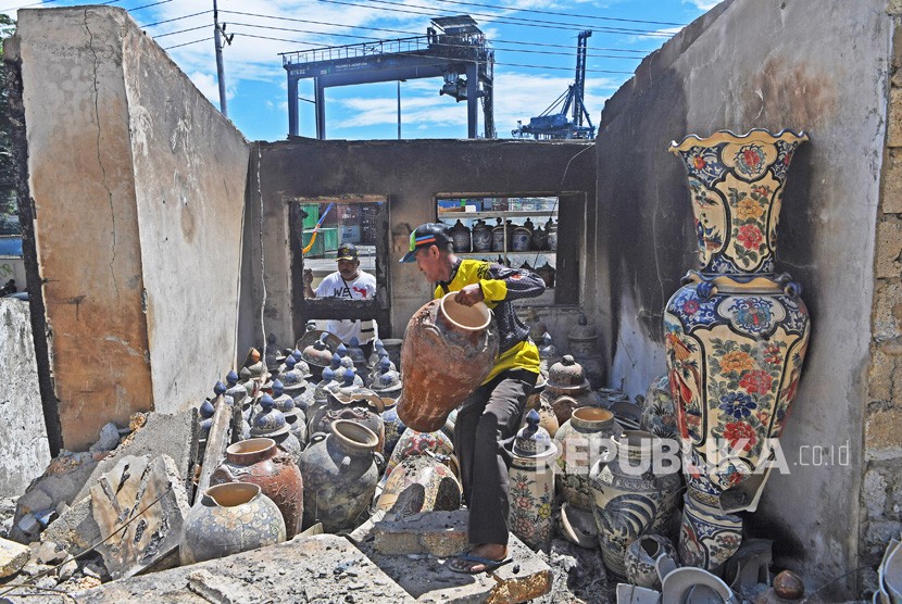 Warga mengumpulkan benda yang masih berharga dari sisa kebakaran rumah warga di Kota Jayapura, Papua, Senin (2/9/2019).